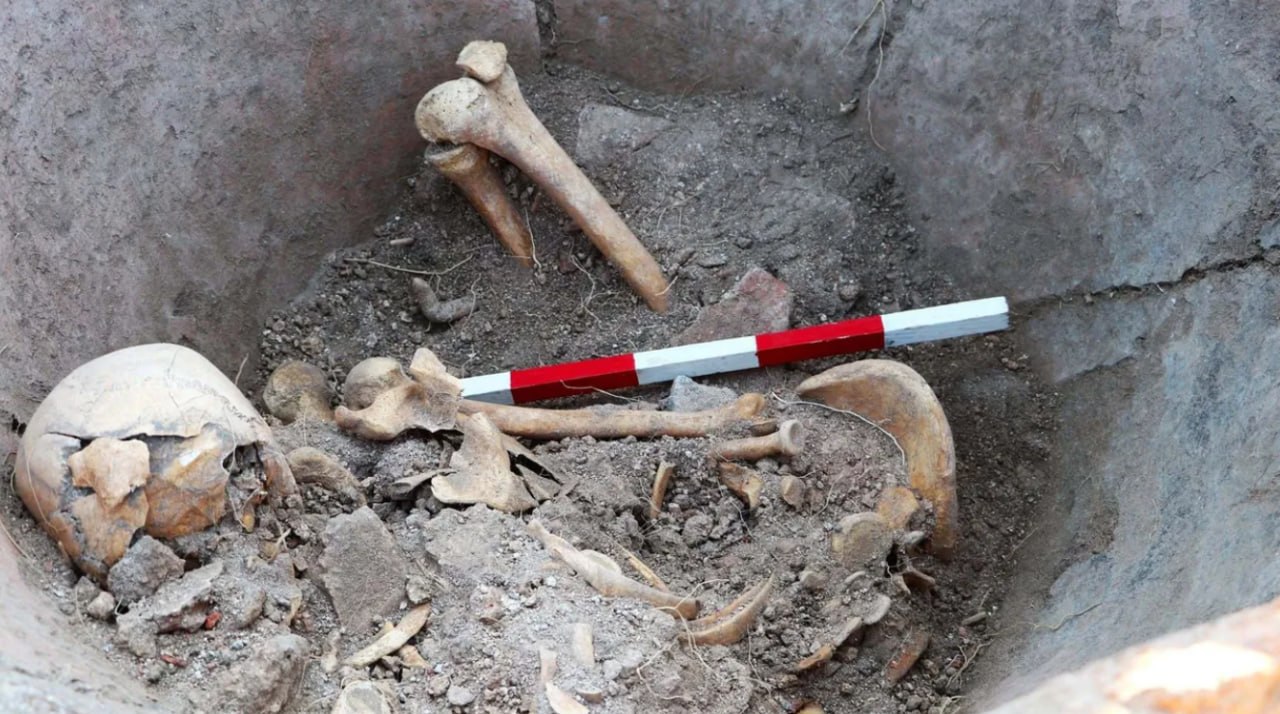 Человеческие останки на дне керамического сосуда при раскопках Деултума